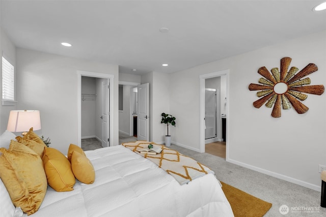 carpeted bedroom with recessed lighting, baseboards, a walk in closet, connected bathroom, and a closet