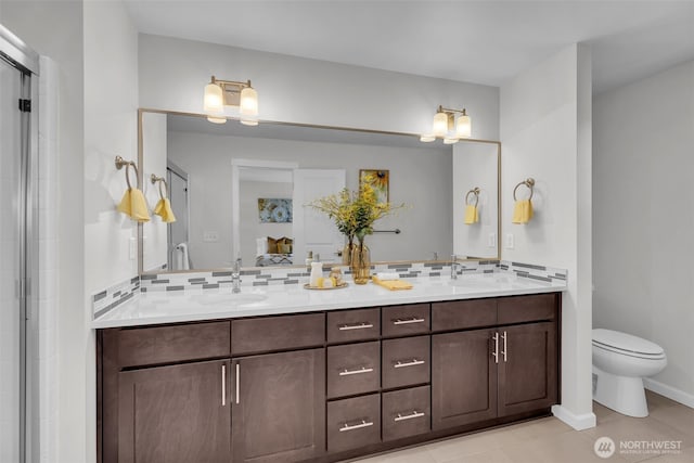 bathroom featuring double vanity, tile patterned floors, toilet, and backsplash
