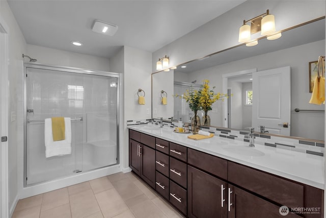 bathroom with a shower stall, double vanity, tile patterned flooring, and recessed lighting