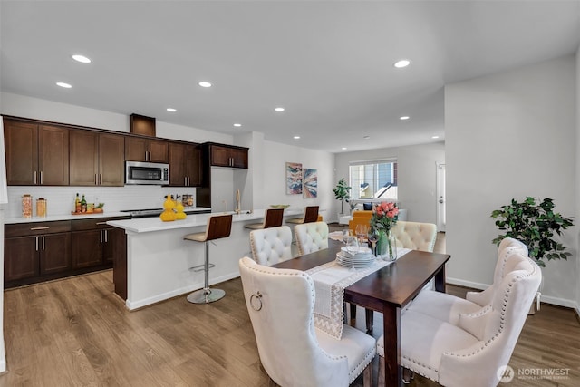dining space featuring light wood finished floors and recessed lighting