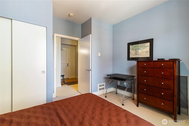 carpeted bedroom with a closet and baseboards