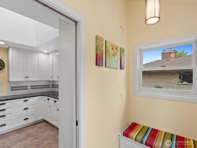 interior space with white cabinetry and dark countertops