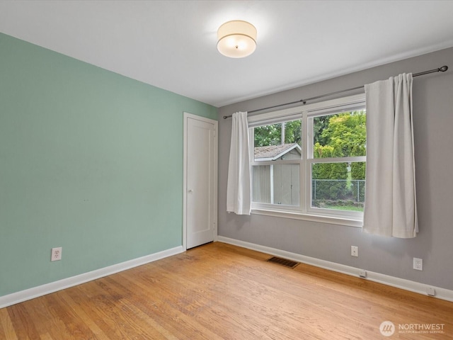 unfurnished room featuring baseboards and wood finished floors