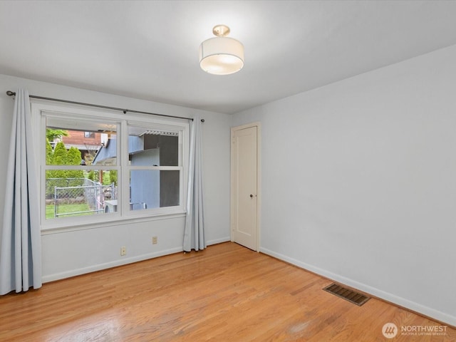 unfurnished room featuring baseboards and light wood-style flooring