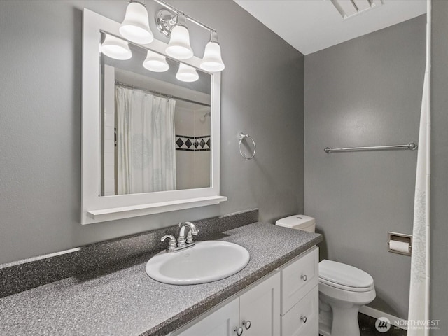 full bathroom featuring toilet, vanity, and a shower with shower curtain
