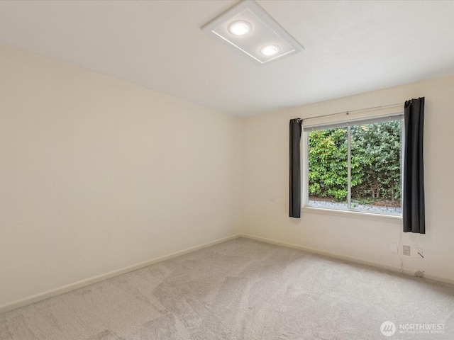 spare room with light carpet, baseboards, and attic access