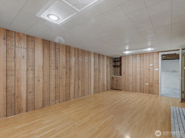 finished below grade area featuring wood finished floors and wooden walls