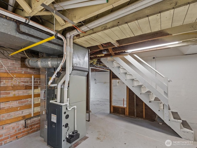 unfinished below grade area featuring stairway and heating unit
