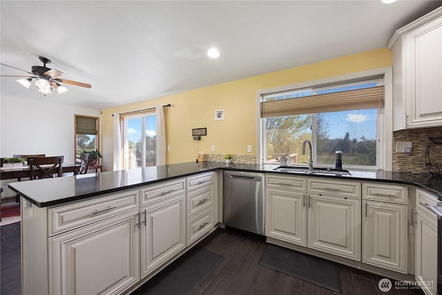 2983 Sonoran Dr, Richland, WA 99354 - kitchen with a peninsula, a ceiling fan, a sink, stainless steel dishwasher, and backsplash
