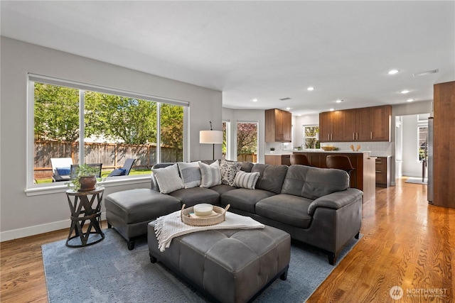 living room featuring recessed lighting, light wood-style floors, and baseboards