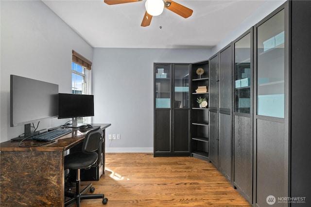 office space featuring light wood-style floors, a ceiling fan, and baseboards