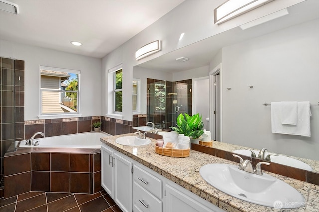 bathroom with a stall shower, a garden tub, tile patterned flooring, and double vanity