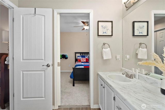 bathroom with a ceiling fan, baseboards, and vanity