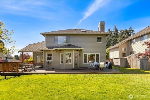 back of house featuring a deck, a chimney, and outdoor dining area