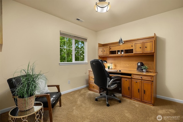 office area featuring light carpet and baseboards