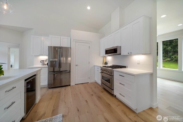39195 Blackmouth Pl NE, Hansville, WA 98340 - kitchen featuring stainless steel appliances, beverage cooler, light wood-style floors, white cabinetry, and light countertops