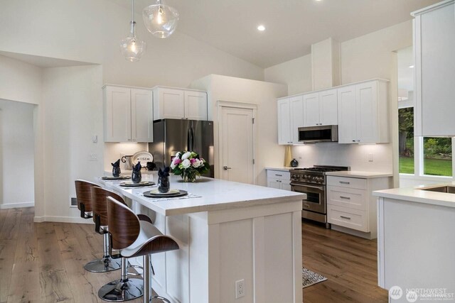 39195 Blackmouth Pl NE, Hansville, WA 98340 - kitchen with appliances with stainless steel finishes, high vaulted ceiling, white cabinetry, light countertops, and light wood-style flooring