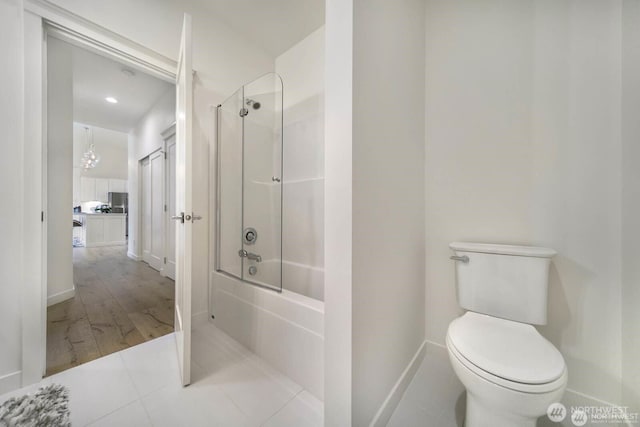 39195 Blackmouth Pl NE, Hansville, WA 98340 - bathroom with washtub / shower combination, toilet, baseboards, and a chandelier