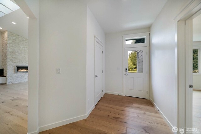 39195 Blackmouth Pl NE, Hansville, WA 98340 - foyer featuring light wood-style flooring, a stone fireplace, baseboards, and recessed lighting