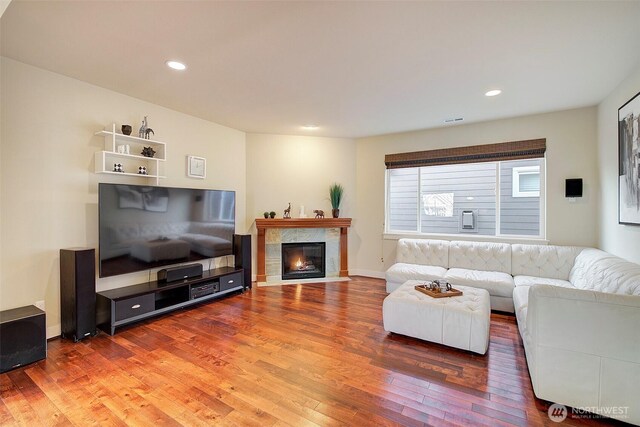 living area featuring wood-type flooring, recessed lighting, and a fireplace