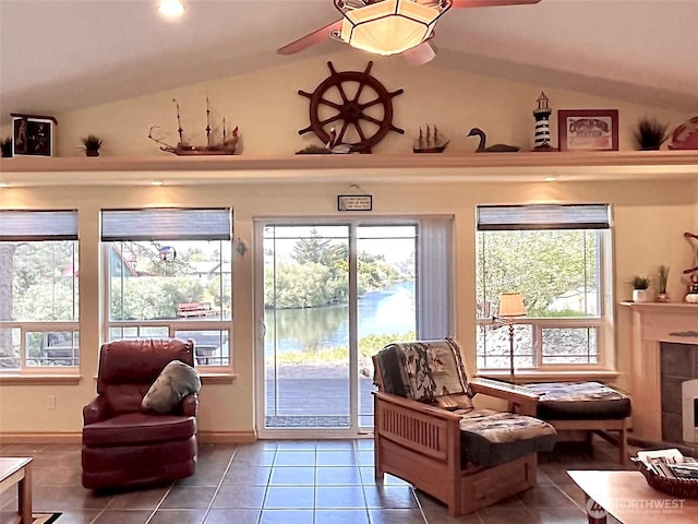 sitting room with tile patterned floors, vaulted ceiling, a ceiling fan, and baseboards