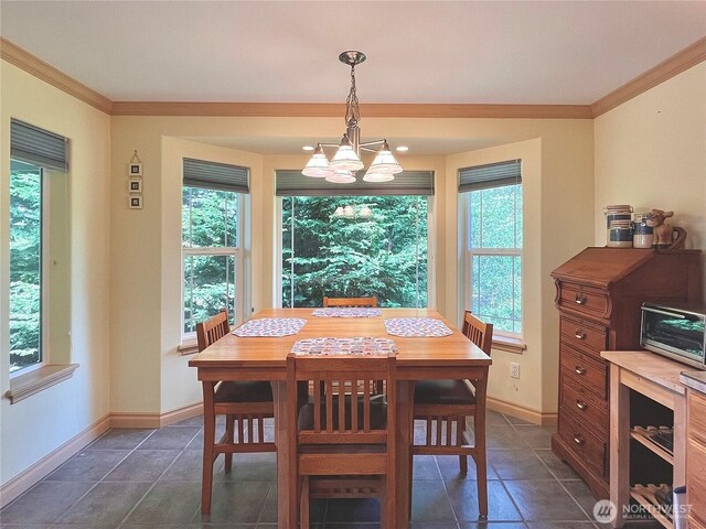 dining room with crown molding, dark tile patterned flooring, a chandelier, and baseboards
