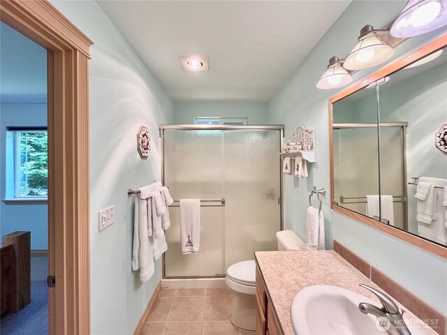 full bathroom featuring toilet, a stall shower, vanity, tile patterned floors, and baseboards