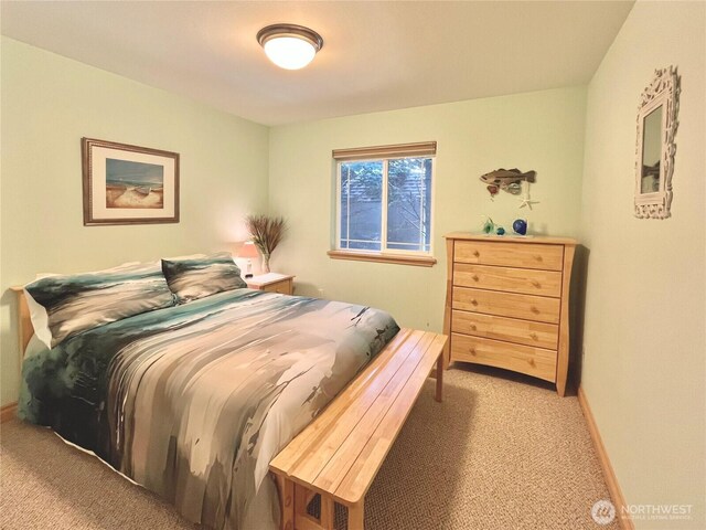 bedroom featuring light carpet and baseboards
