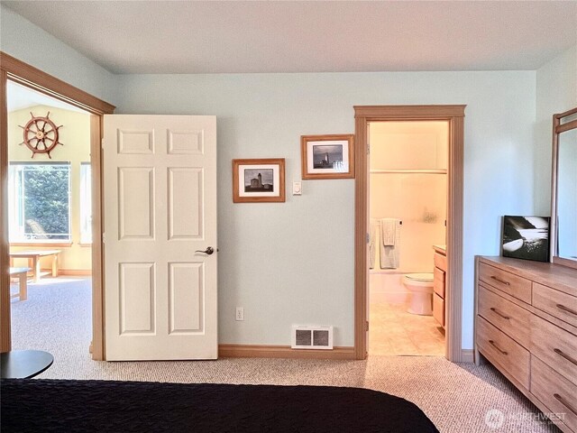 bedroom featuring carpet floors, baseboards, and ensuite bath