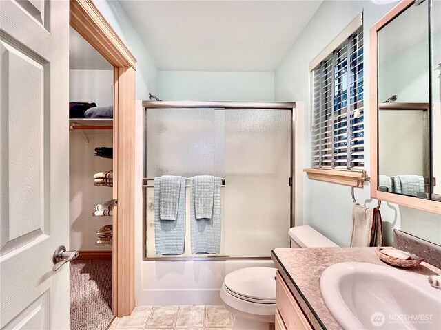 bathroom featuring bath / shower combo with glass door, vanity, and toilet
