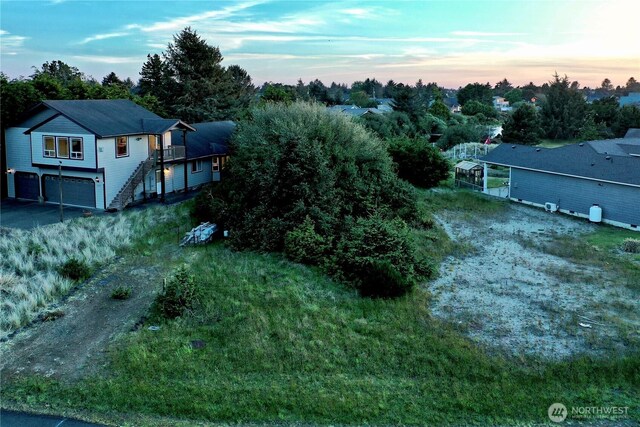 view of subject property featuring a tree filled landscape