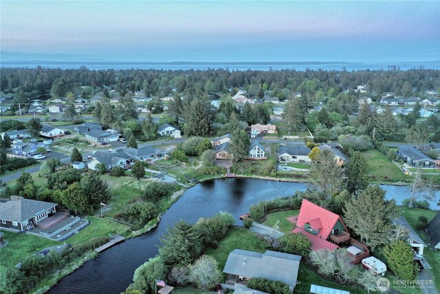 aerial view at dusk of a water view and a residential view
