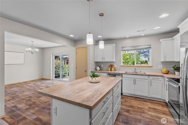 3612 64th St E, Tacoma, WA 98443 - kitchen with stainless steel electric range, butcher block counters, plenty of natural light, white cabinetry, and recessed lighting