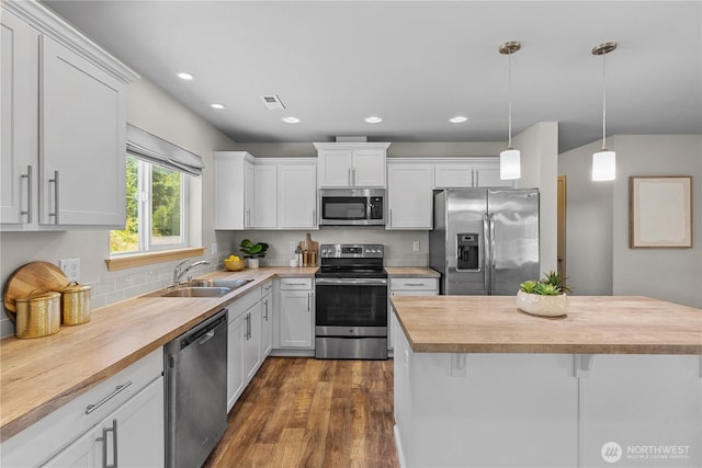 3612 64th St E, Tacoma, WA 98443 - kitchen featuring stainless steel appliances, butcher block countertops, white cabinets, a kitchen island, and pendant lighting
