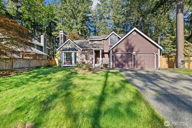 traditional-style house with a garage, asphalt driveway, and a chimney