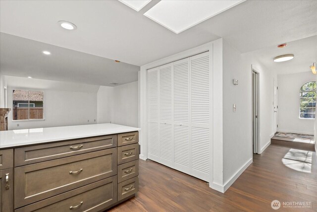 kitchen with dark wood-style flooring, light countertops, recessed lighting, and baseboards