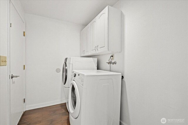 washroom featuring dark wood finished floors, baseboards, washing machine and dryer, and cabinet space