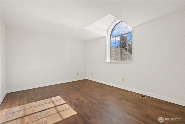 unfurnished room with baseboards, wood finished floors, and lofted ceiling