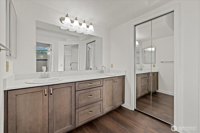 full bathroom with double vanity and wood finished floors