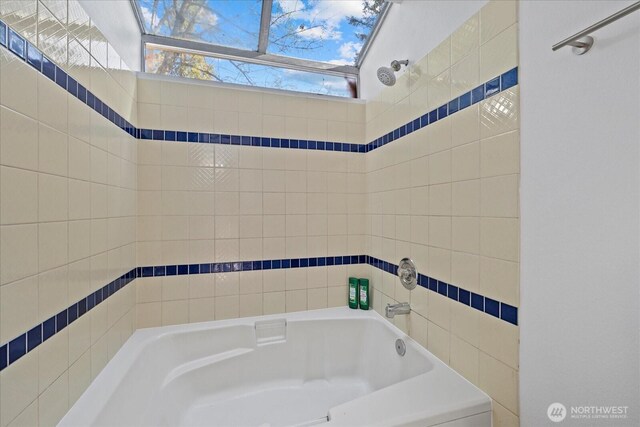 bathroom with a skylight and a tub to relax in