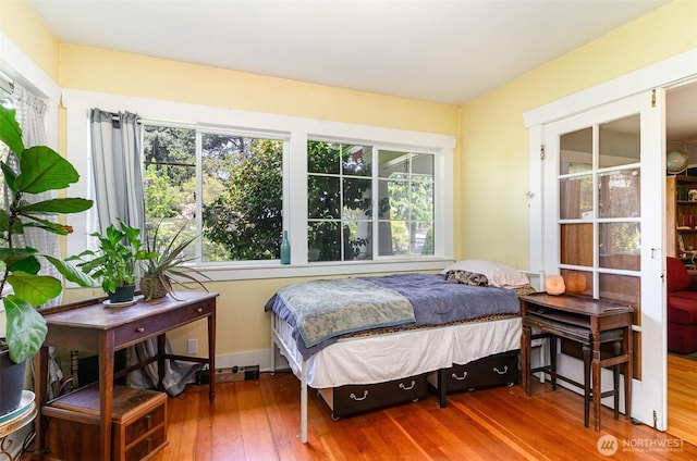 bedroom with wood-type flooring and multiple windows