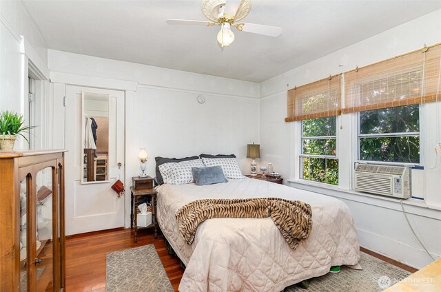 bedroom featuring wood finished floors, cooling unit, and a ceiling fan