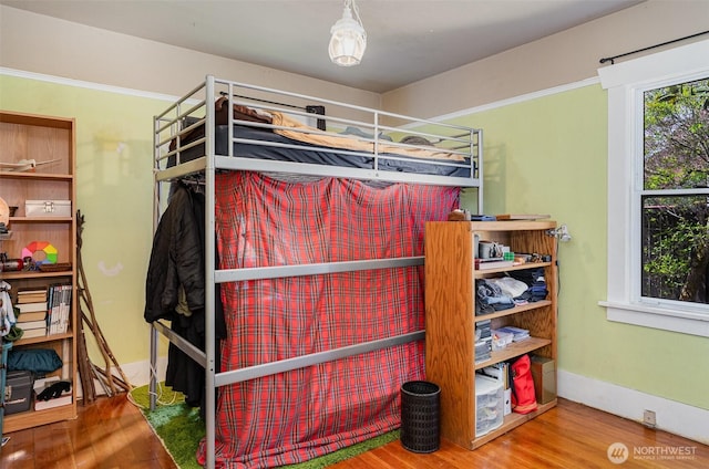 bedroom featuring wood finished floors and baseboards