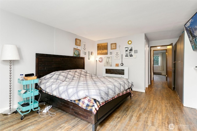 bedroom with wood finished floors and baseboards