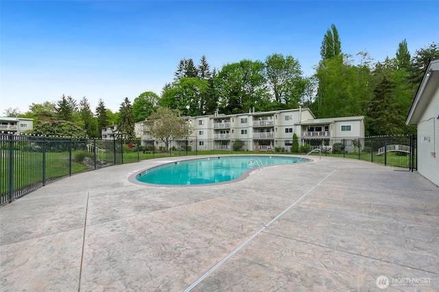 community pool with a patio and fence