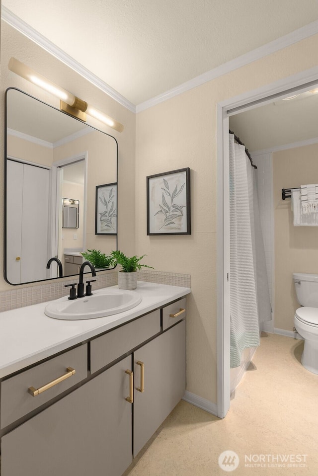 bathroom with toilet, vanity, ornamental molding, baseboards, and a shower with curtain