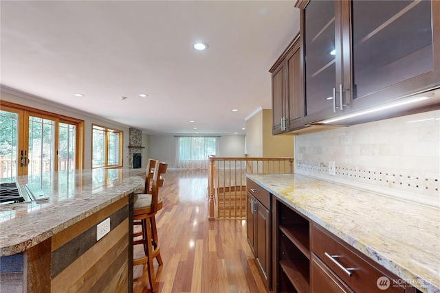 2022 Scarpelli Dr, Walla Walla, WA 99362 - kitchen featuring light wood-style floors, decorative backsplash, recessed lighting, glass insert cabinets, and light stone counters
