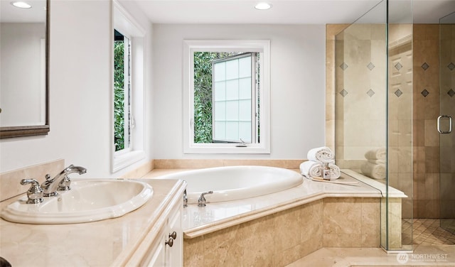 full bathroom featuring a stall shower, vanity, a bath, and recessed lighting