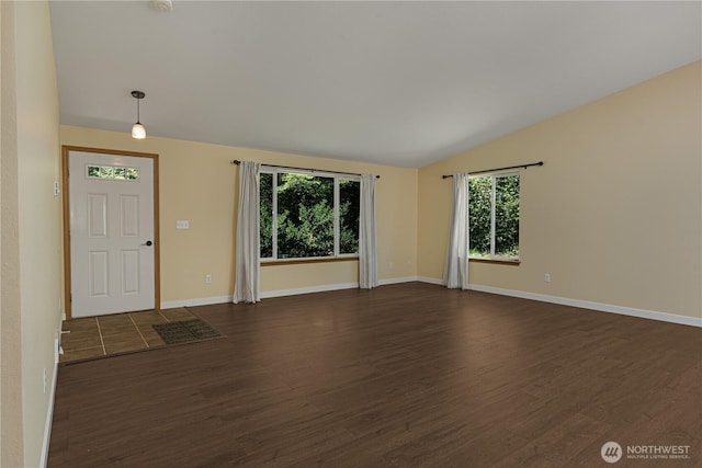 entrance foyer with dark wood-type flooring, lofted ceiling, and baseboards