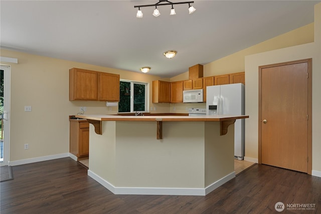 kitchen featuring white appliances, dark wood-type flooring, a kitchen breakfast bar, lofted ceiling, and light countertops